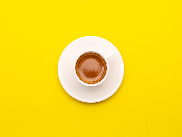 Top view espresso coffee in white cup on yellow
 background